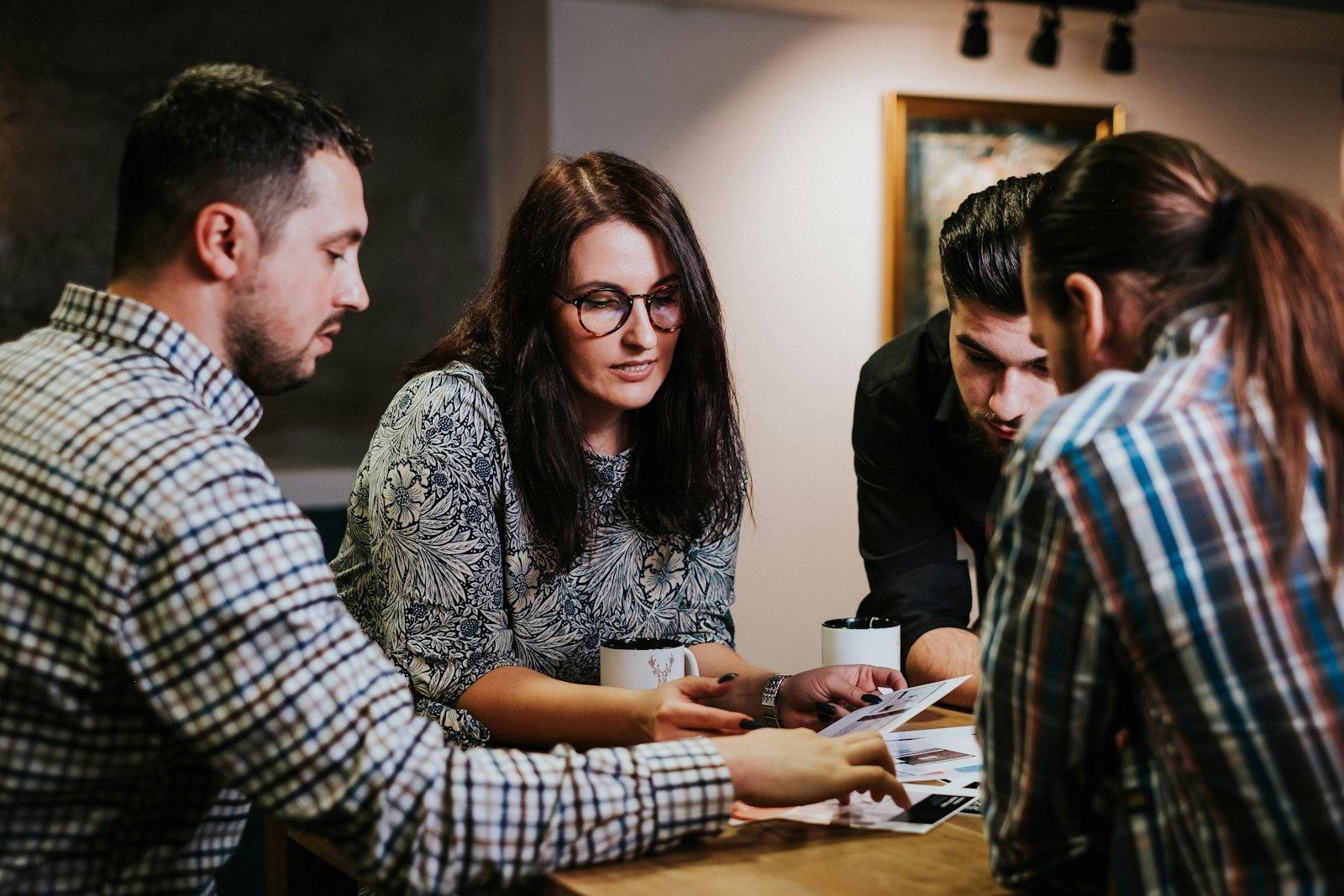 Four colleagues reviewing documents at a table