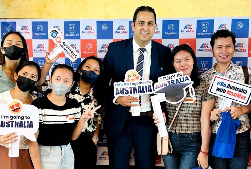 Students holding Study in Australia signs with the MaxiMax team