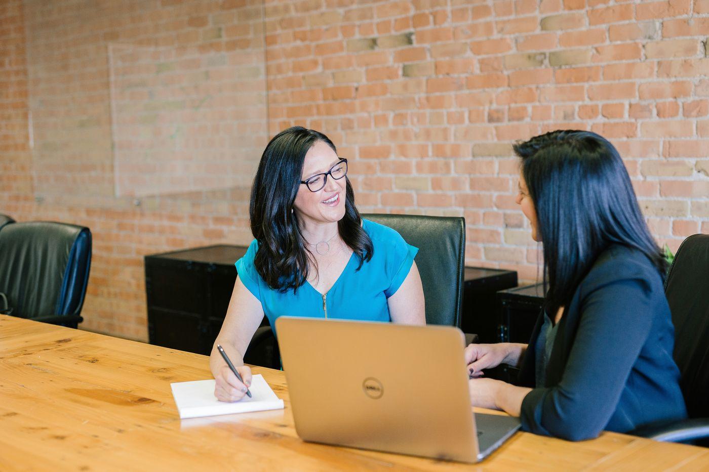 A counsellor and a student talking over a laptop
