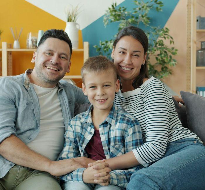 A couple and their son sitting together at home