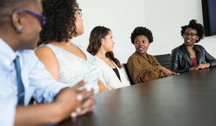 Colleagues talking around a meeting table